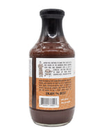 18 oz Bottle of Texas craft sauce Franklin Barbecue Espresso Sauce with back side of label showing a barcode and a caricature of Aaron Franklin wearing a robe next to a grill on a white background.