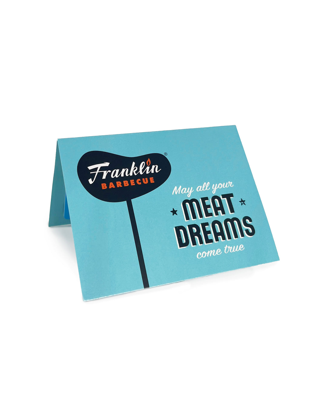 Turquoise blue card with Franklin Barbecue sign and text saying "May all of your meat dreams come true". Card is folded in half