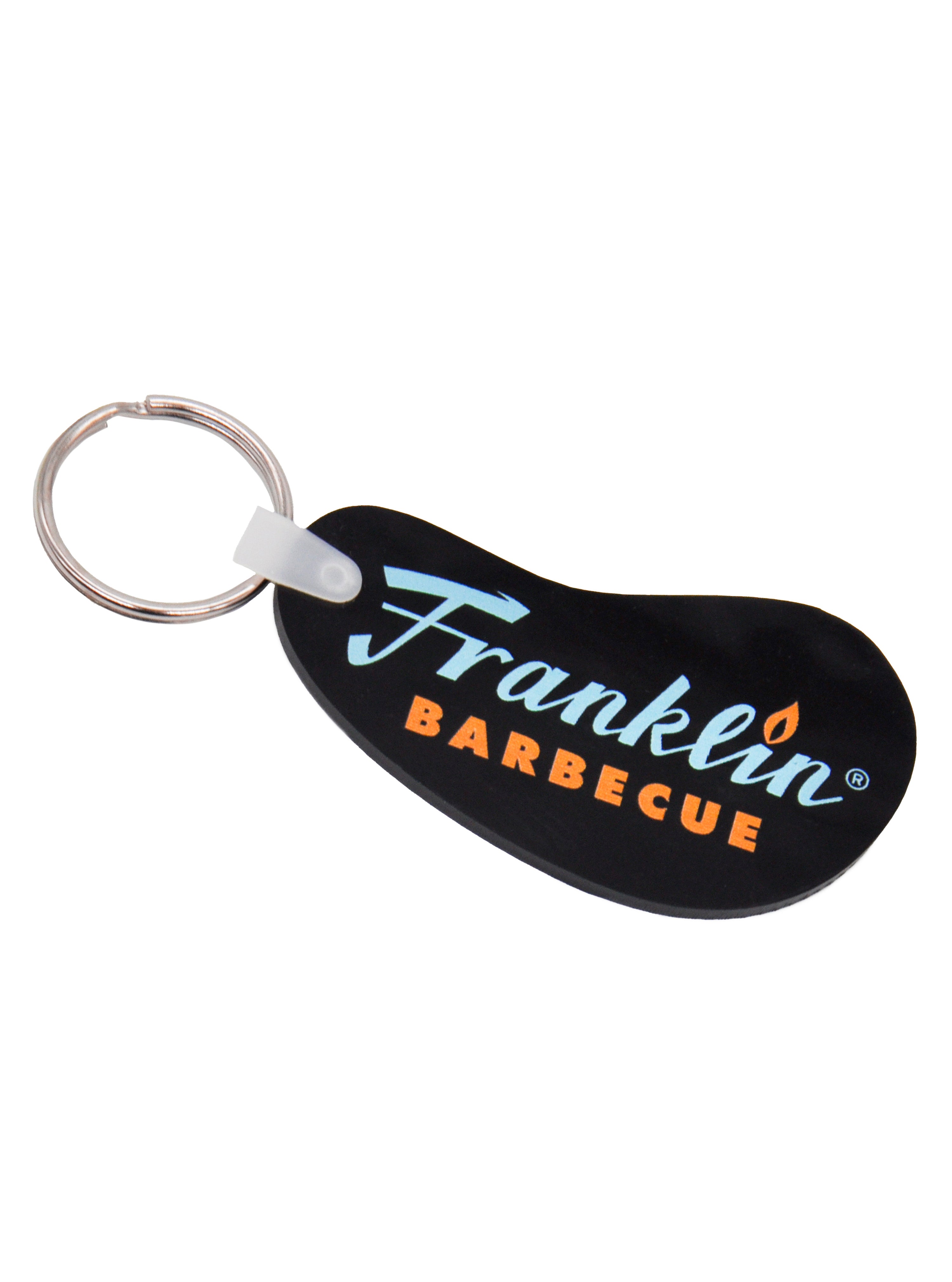 Black bean shaped vinyl keychain with blue and orange Franklin Barbecue logo. A silver metal key ring on the left side.