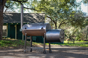 barbecue smoker with oak trees in the background