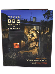 Cover of Wyatt McSpadden's book Texas BBQ Small Town to Downtown. Image shows Aaron Franklin looking into smoker.