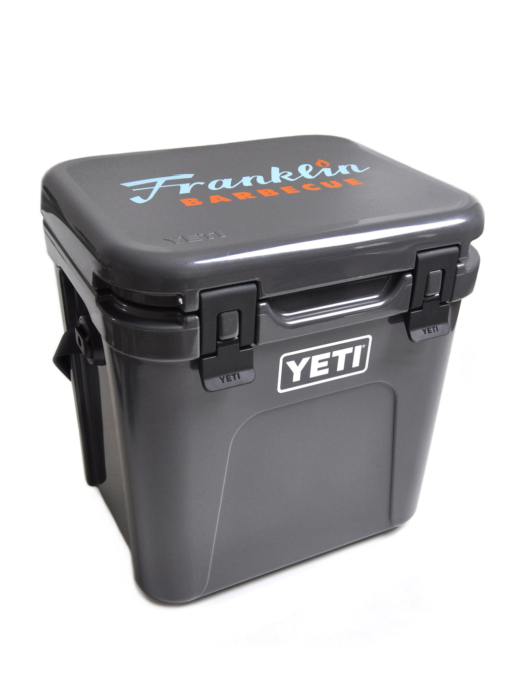 Gray Franklin Yeti Roadie cooler with blue and orange Franklin Barbecue logo on lid and white YETI logo on front face
