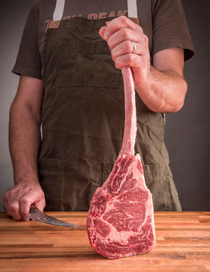 Aaron Franklin modeling the Franklin Barbecue Pits Weige Trimming Knife with stainless steel blade and solid brass pins on wood handle while holding meat