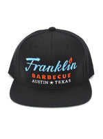 Black cap with Franklin Barbecue text logo in blue and orange. Below that is Austin Texas in white.
