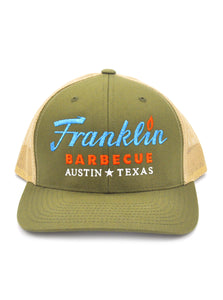 Moss green cap with khaki colored mesh sides. Franklin Barbecue text logo in blue and orange. Below that is Austin Texas in white.