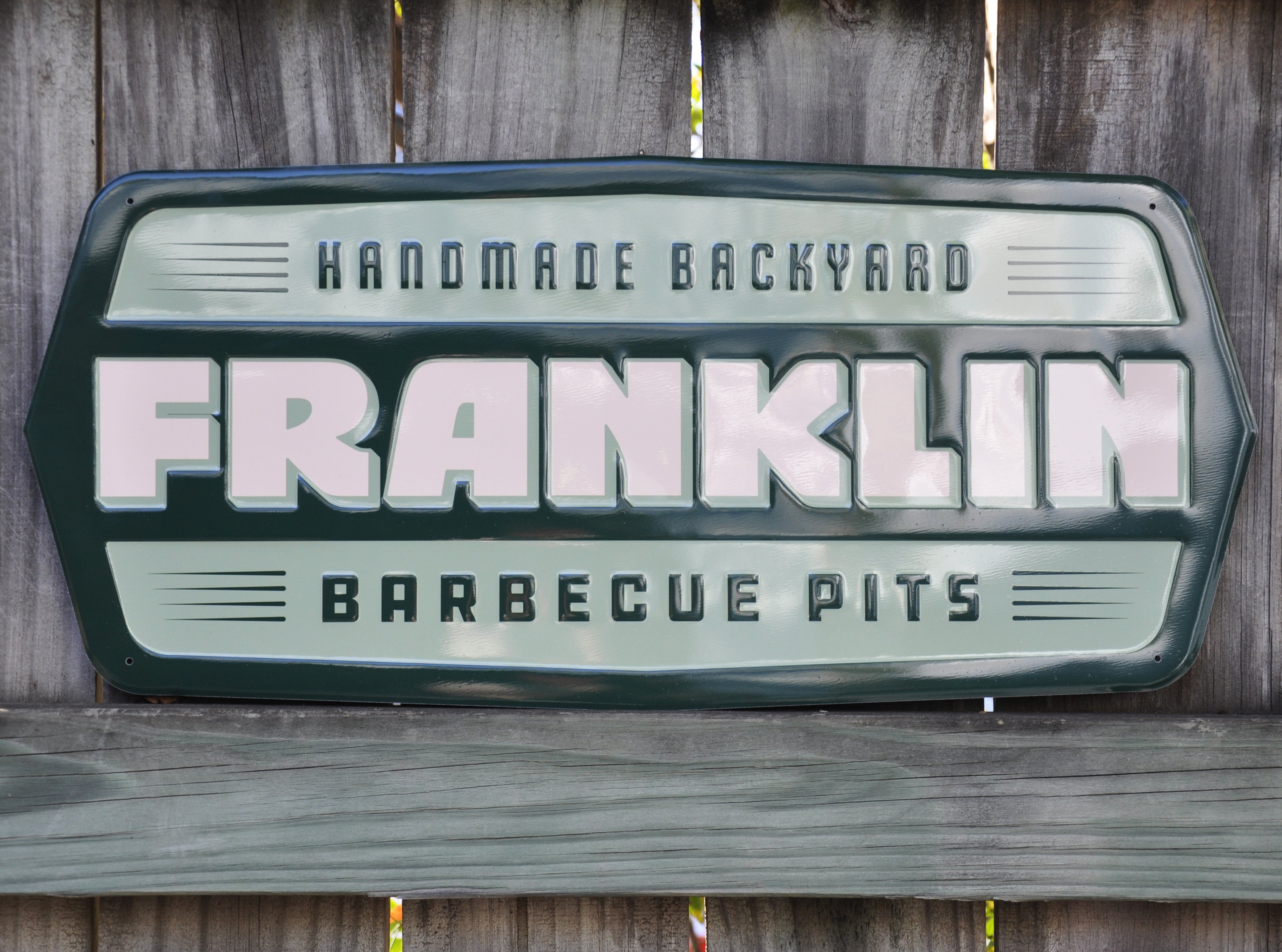 Franklin Pits tacker sign displayed outside on a wooden fence.