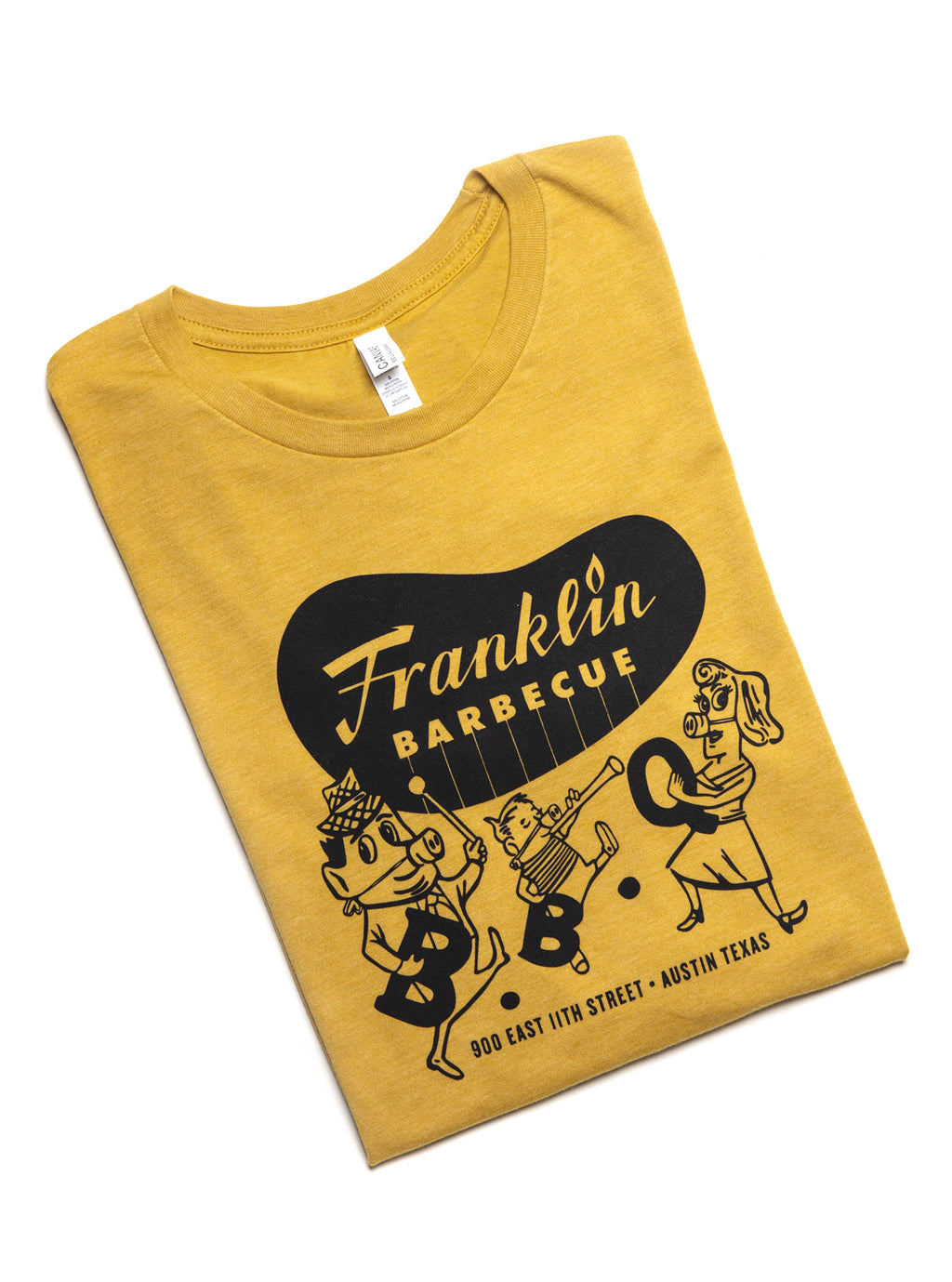 Heather yellow t-shirt with Franklin Barbecue bean Logo in black and illustration of dancing family holding the letters B-B-Q while wearing pig-nose masks also in black. Below the dancing family is the address of Franklin Barbecue also in black.